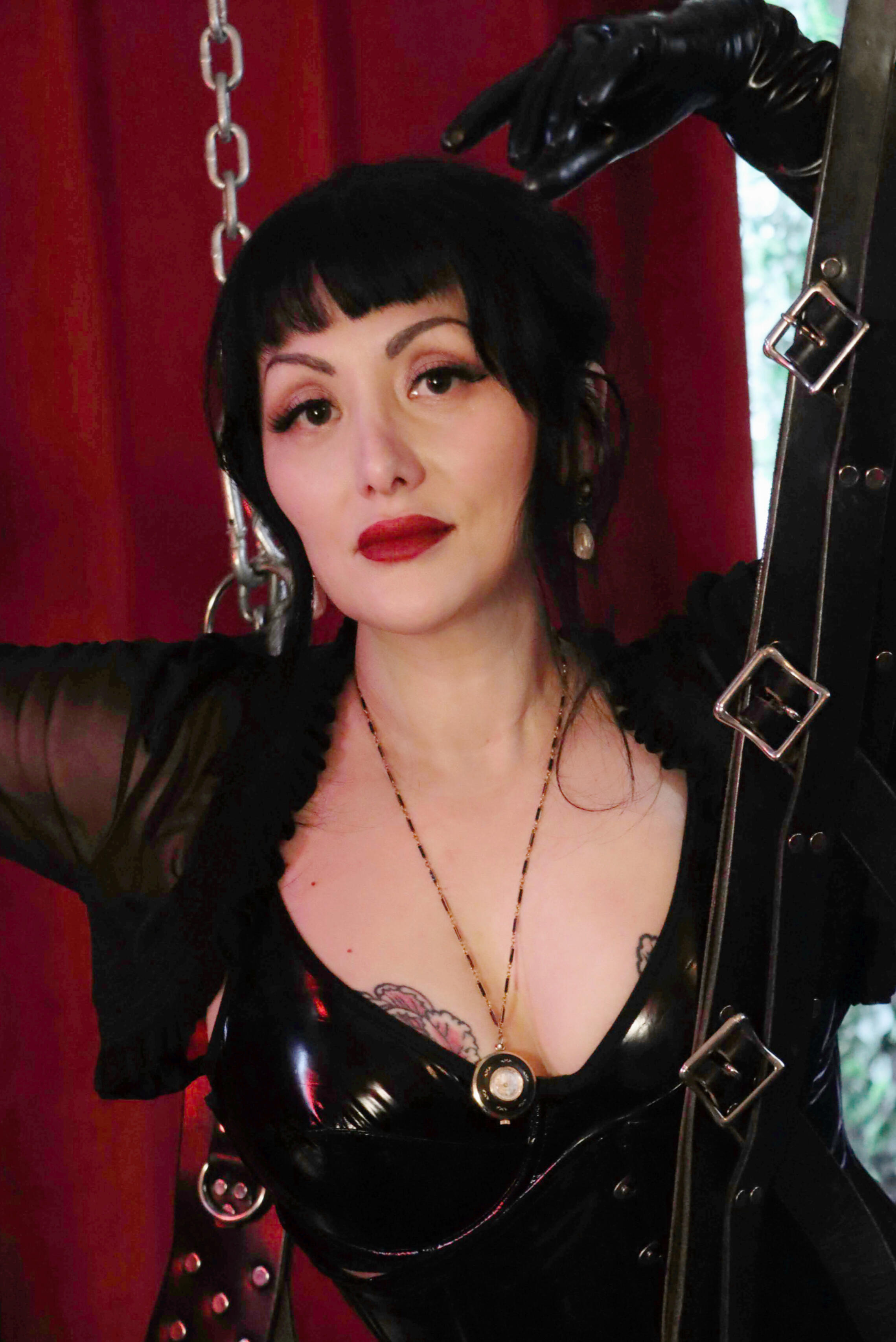 Madame Belladonna, Portland BDSM session in corset, latex, and leather bondage swing